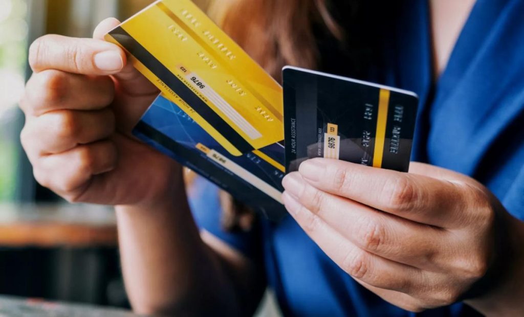 Mujer sosteniendo tarjetas de crédito.