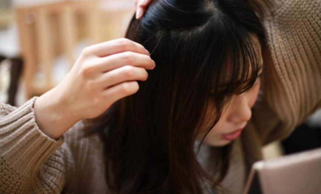 Mujer arrancándose las canas