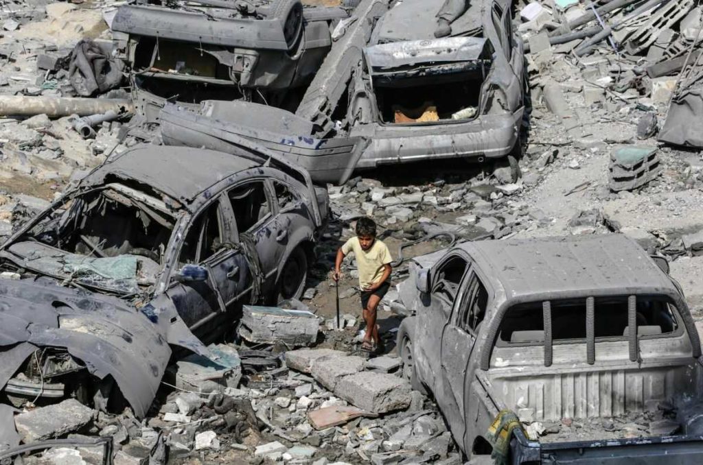 Niño palestino recorre calles destruídas tras ataques de Israel, en Gaza.