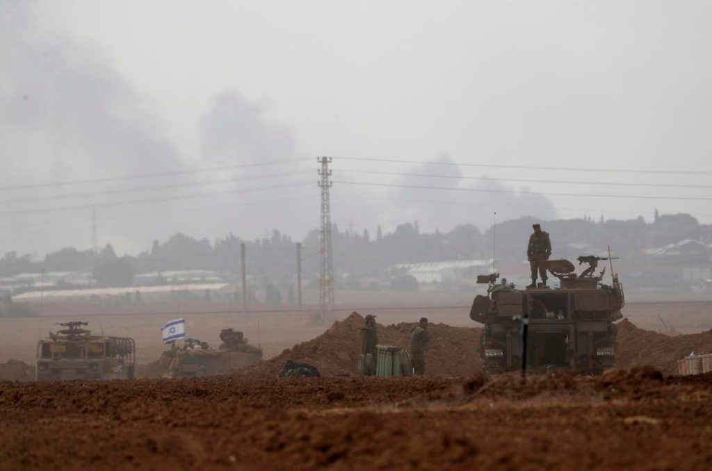 Soldados israelíes en vehículos militares recorren un área a lo largo de la frontera con Gaza, en el sur de Israel