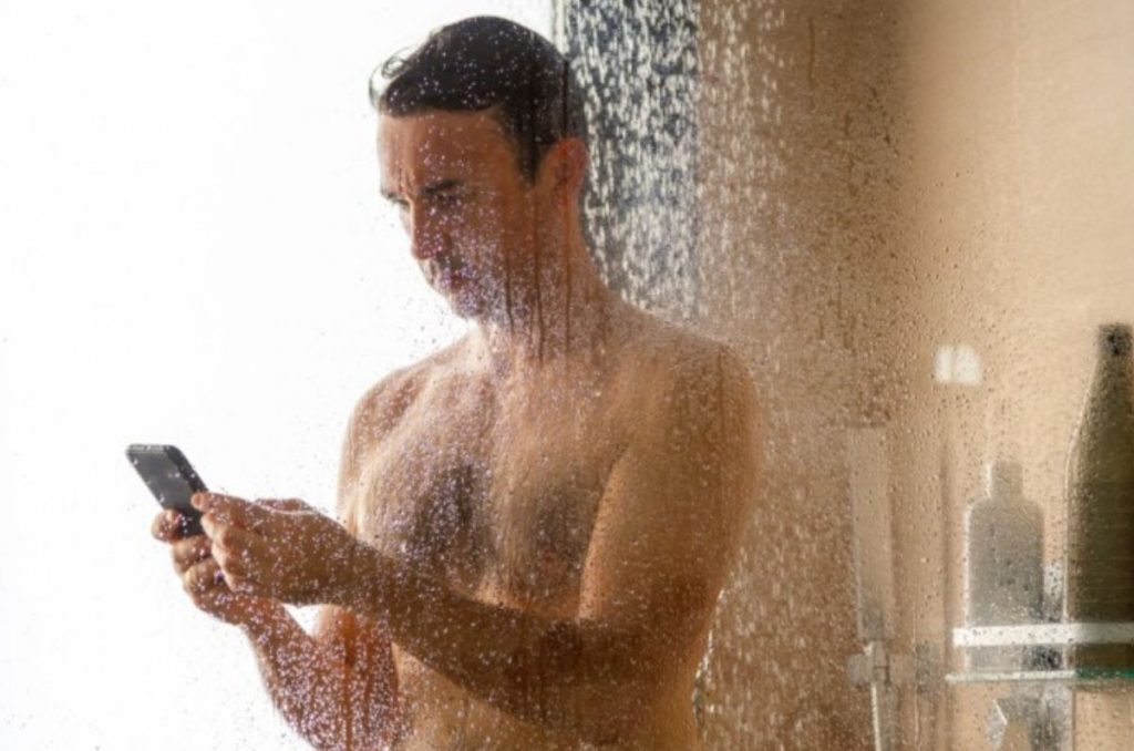 Persona usando el celular en la ducha