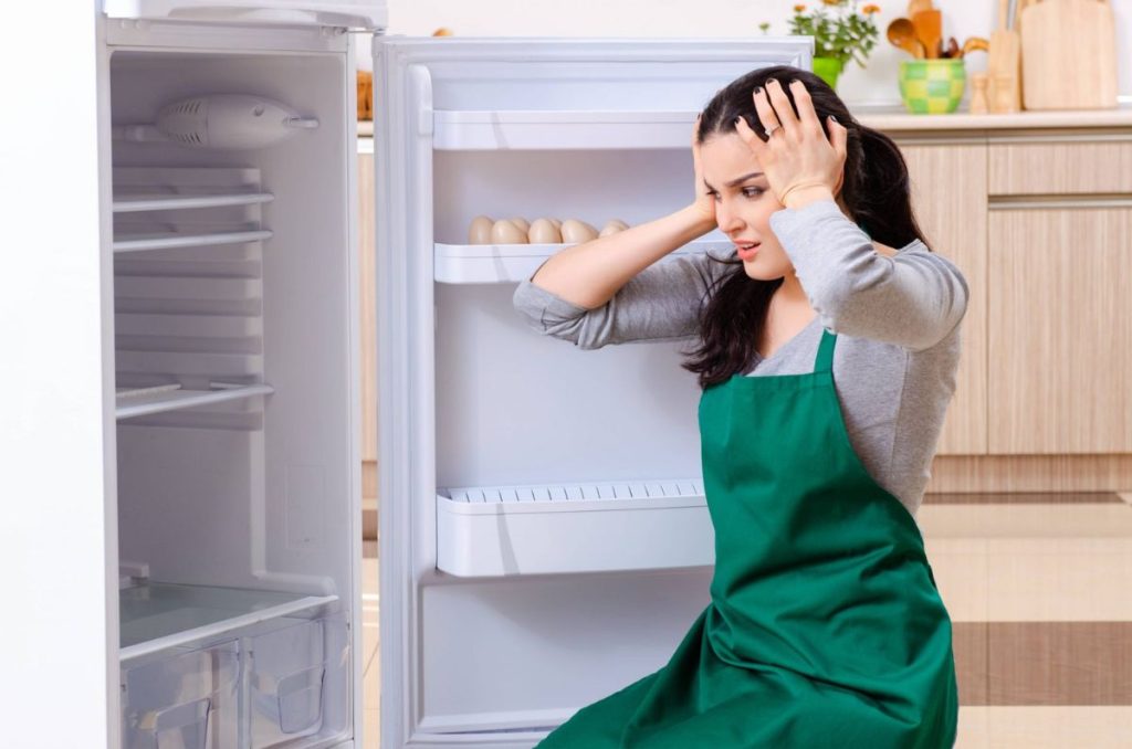 Persona revisando su refrigerador